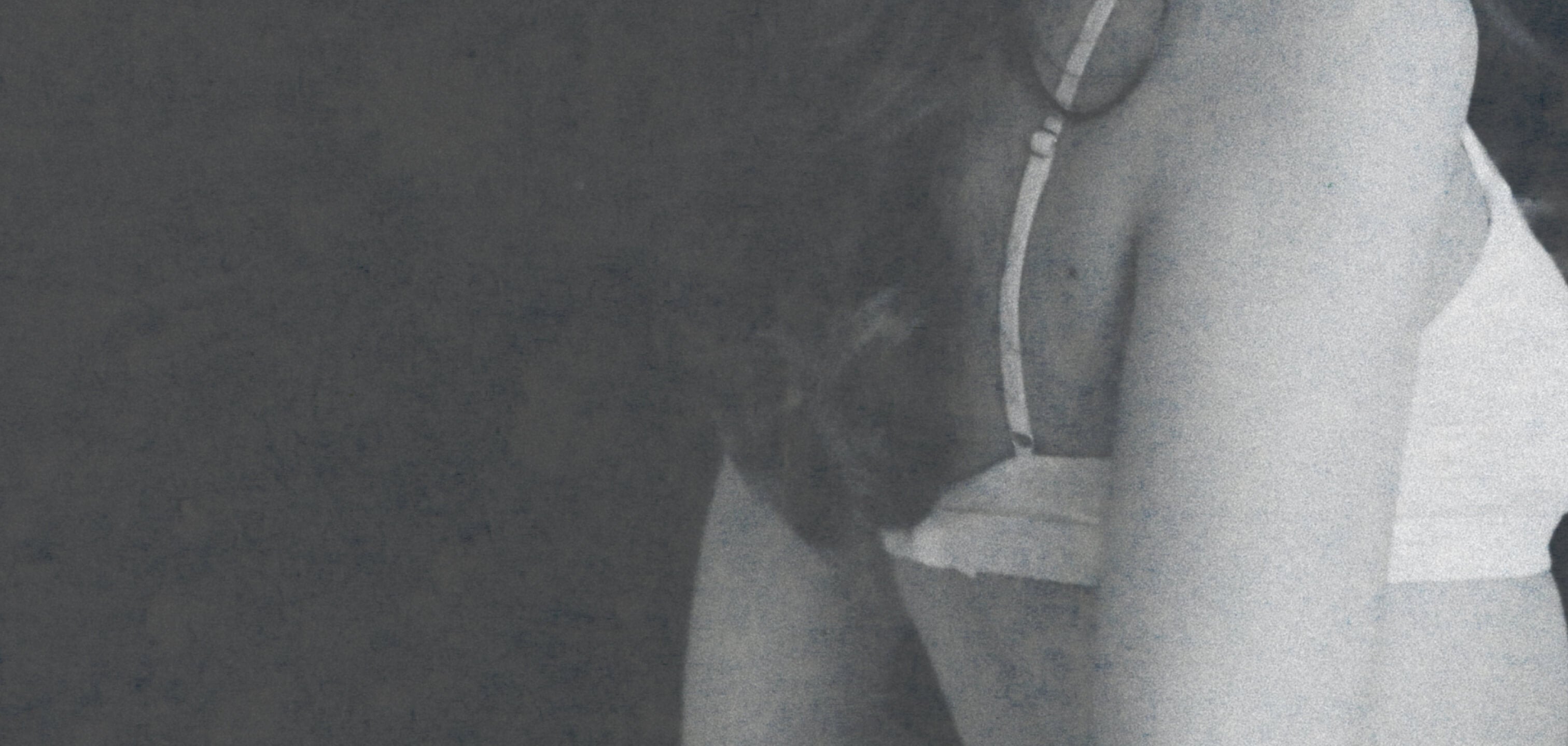 Partial view of a person wearing a Lunaleila bra set against a dark background